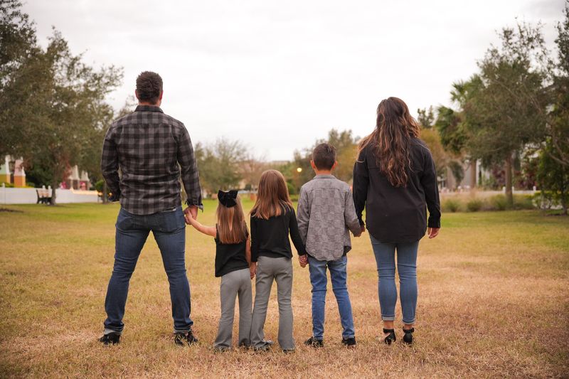 The Bravenboer family, hand in hand, looking out across a field